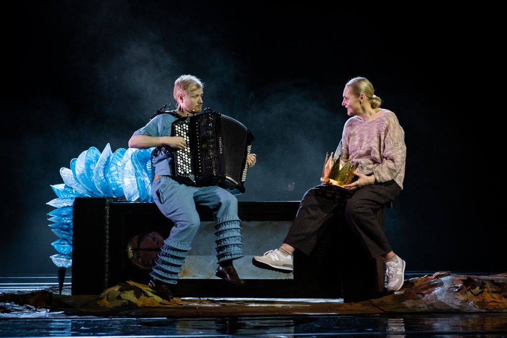 Alicja, ubrana w wygodny, sportowy strój rozmawia z panem Dżdżownicą, grającym na akordeonie. Siedzą na ławce. Mężczyzna gra, ona do niego mówi. W wyglądzie Pana Dżdżownicy zwraca uwagę długi, niebieski ogon, układający się w harmonijkę i zwisający z ławki, a także spodnie o nogawkach zrolowanych na dole.