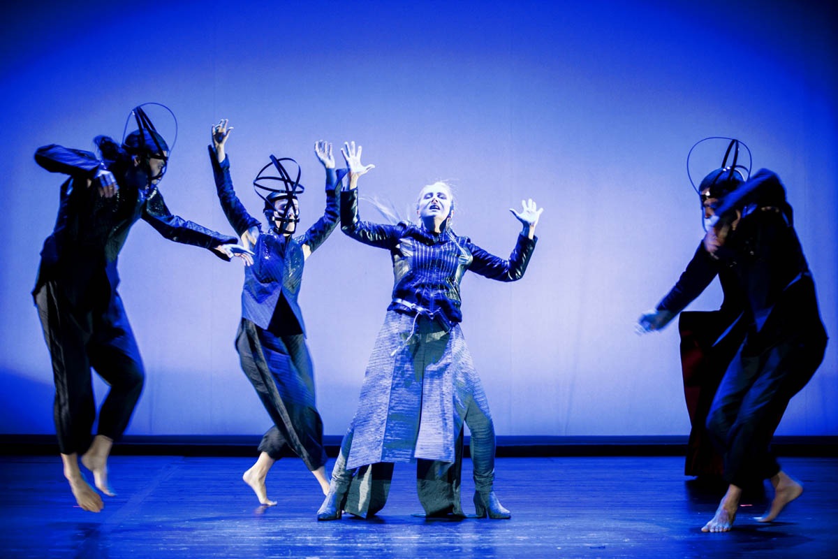 4. Cztery postacie w dużych nakryciach głowy i w obcisłych strojach ukazane w dynamicznym ruchu.