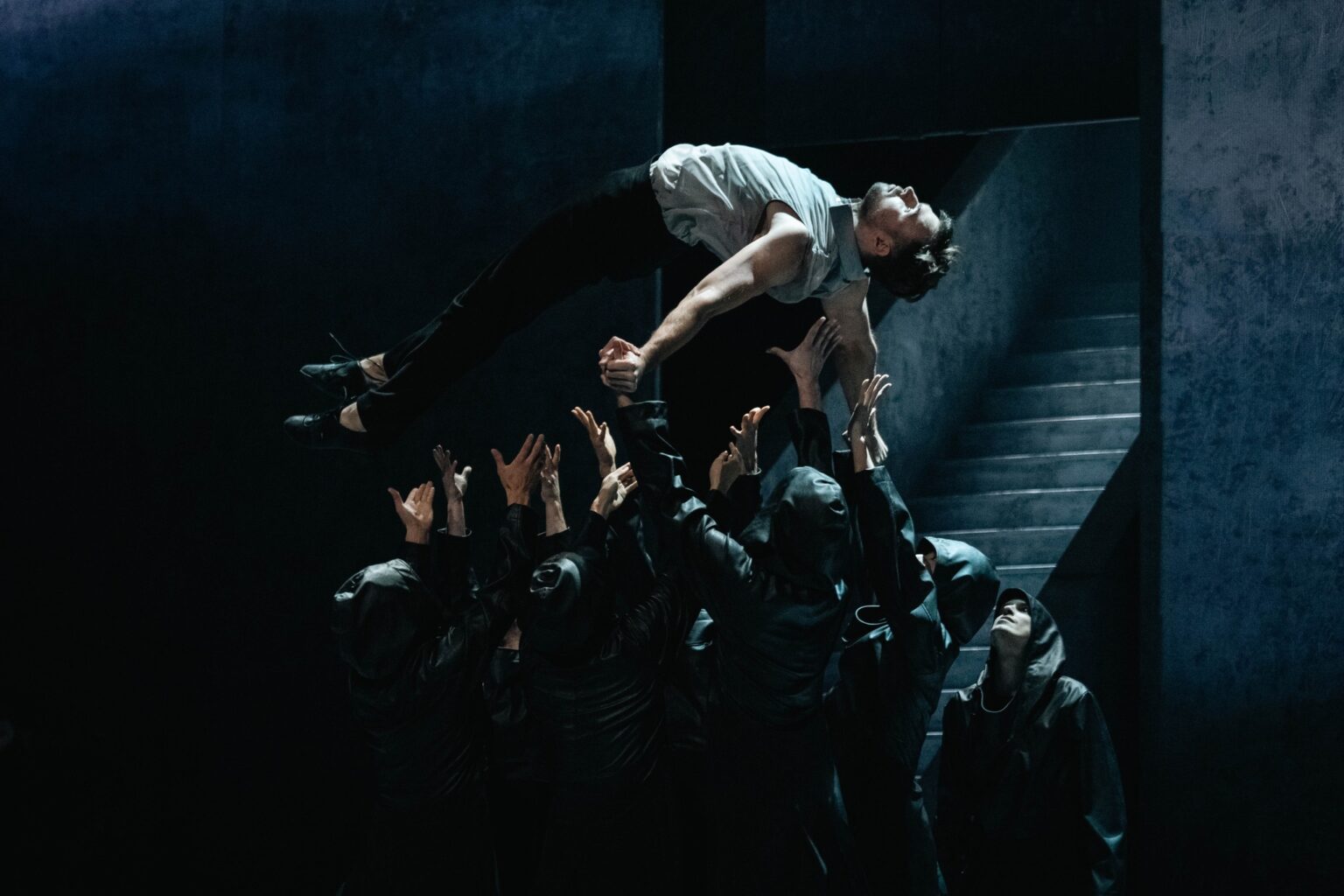 grupa tancerzy podrzuca mężczyznę do góry