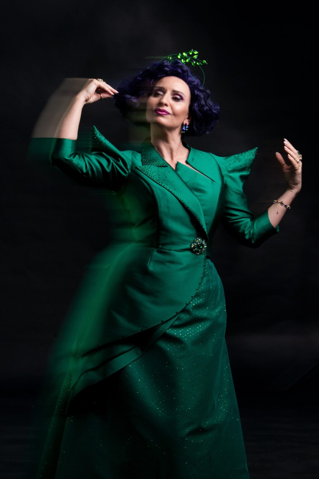 Kobieta w fioletowej peruce, ubrana w zieloną sukienkę