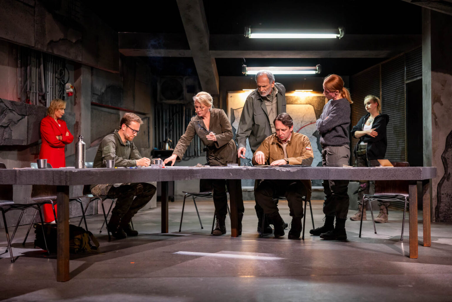 zdjęcie przedstawiające grupę ludzie pochylonych nad stołem