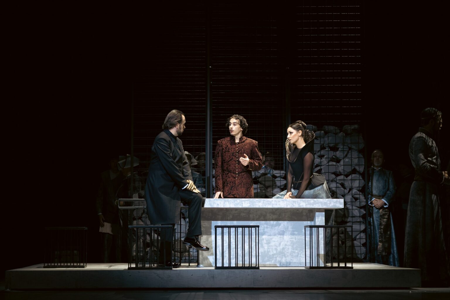 Na zdjęciu trzech aktorów stojących przy dużym stole