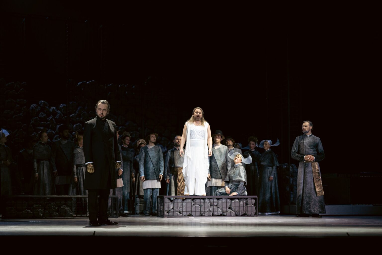 Na zdjęciu aktorzy ubrani w kostiumy utrzymane w kolorystyce szarości, dopełnione złotem.