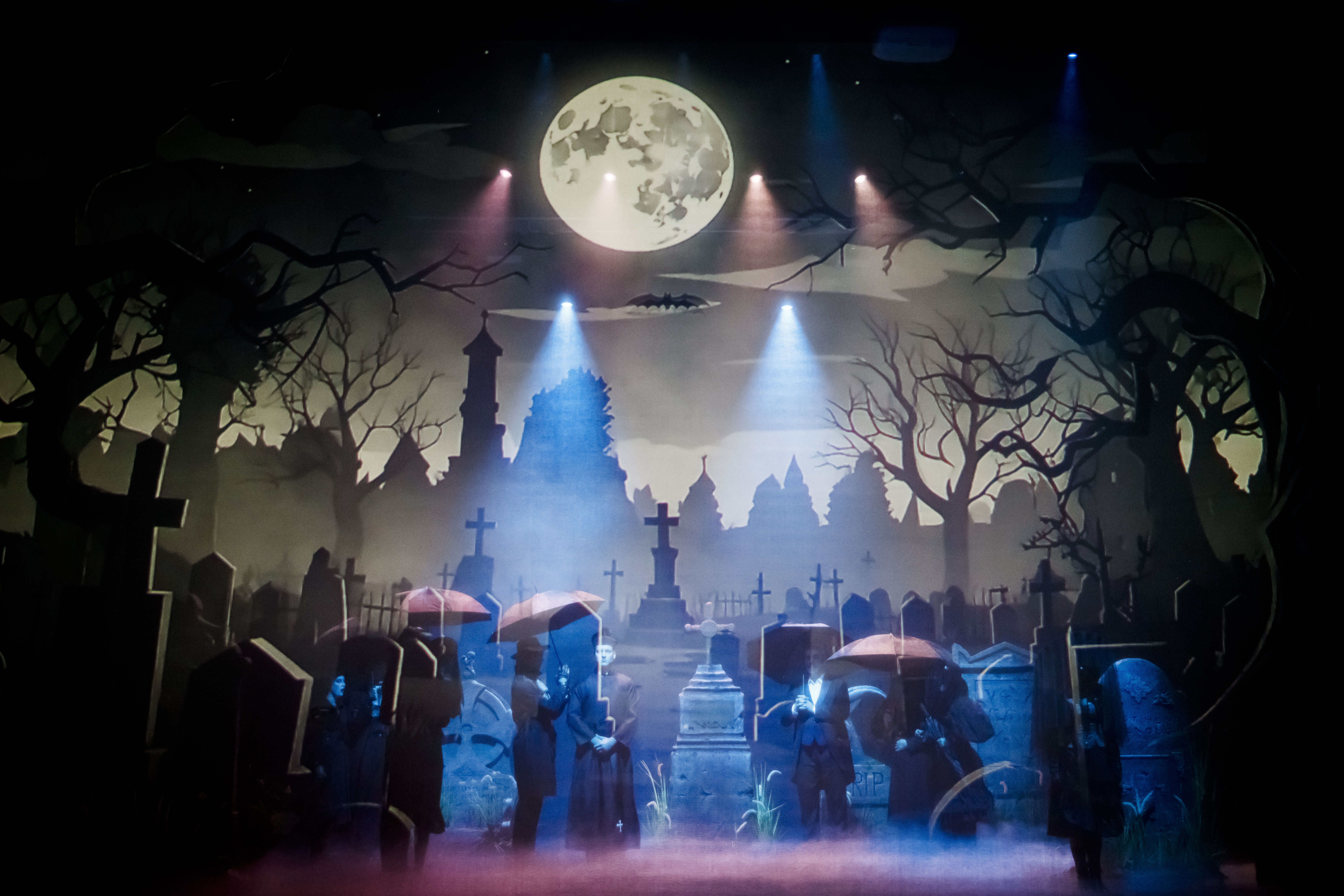 Zdjęcie na którym widać sporo nagrobków, ustawionych na tle ekranu, na którym wyświetlany jest cmentarz.