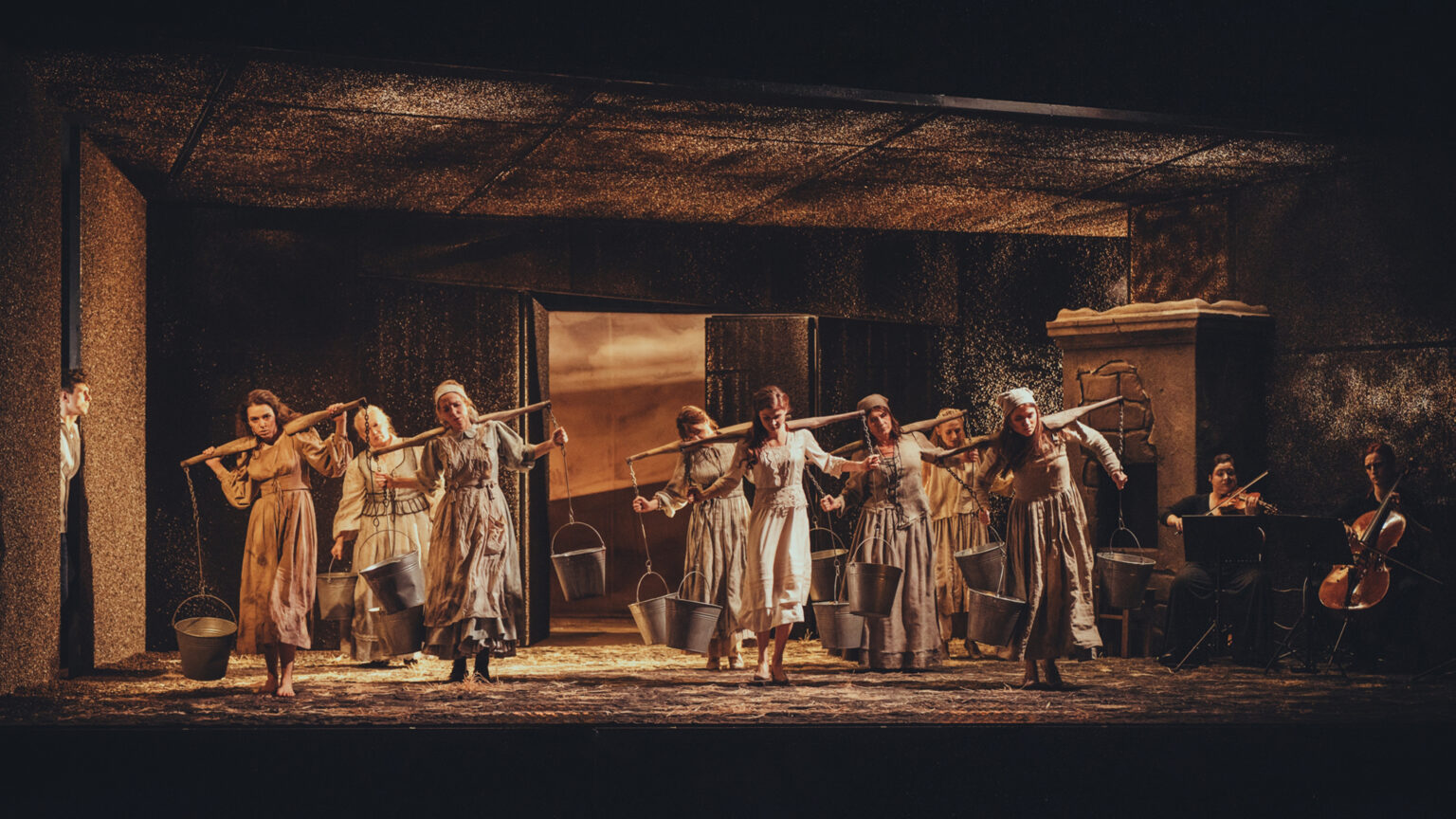 Zdjęcie przedstawia grupę kobiet trzymających na plecach nosidła do wody