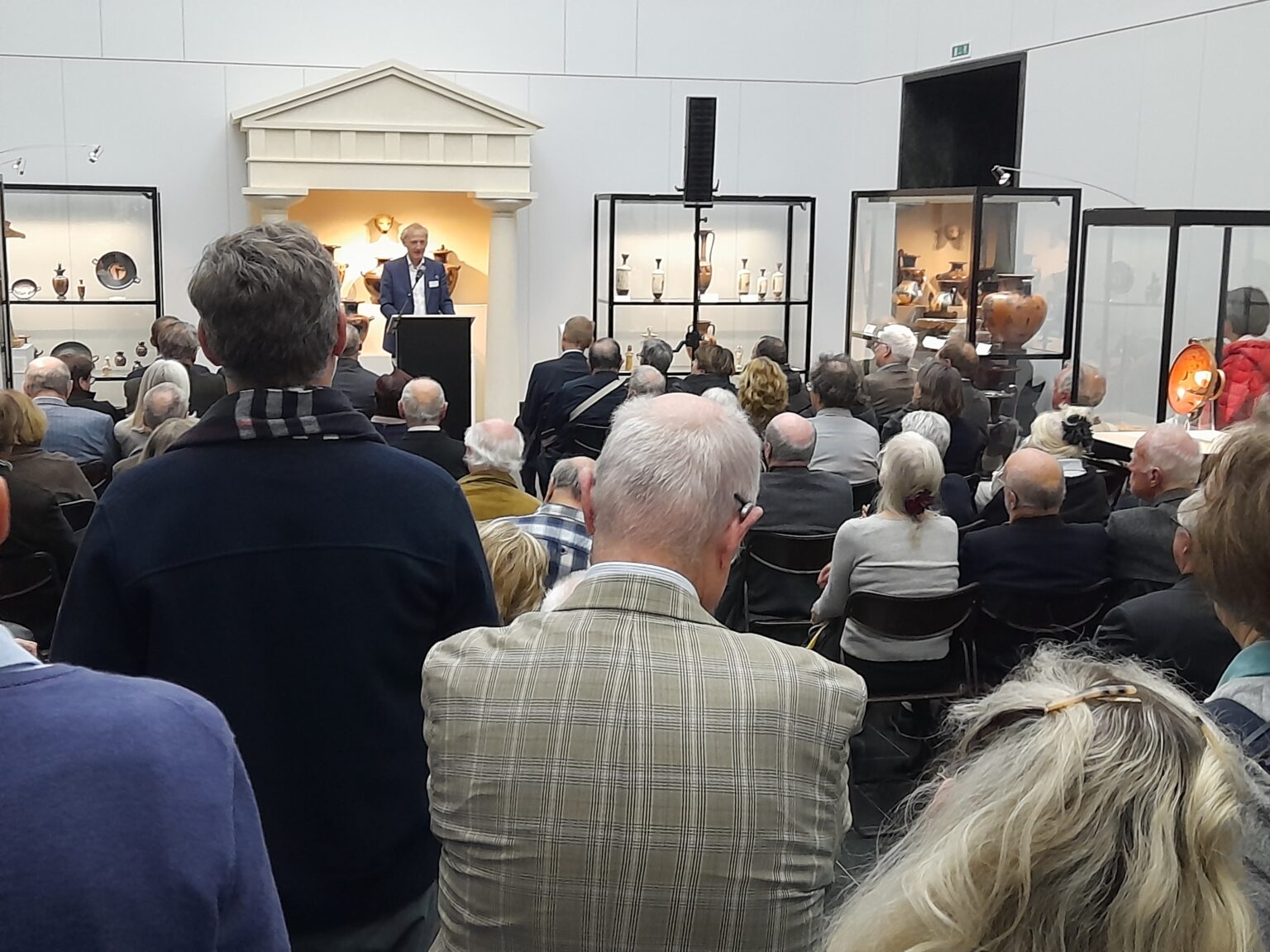 zdjęcie ukazujące Wernisaż w którym bierze udział duża grupa ludzi.