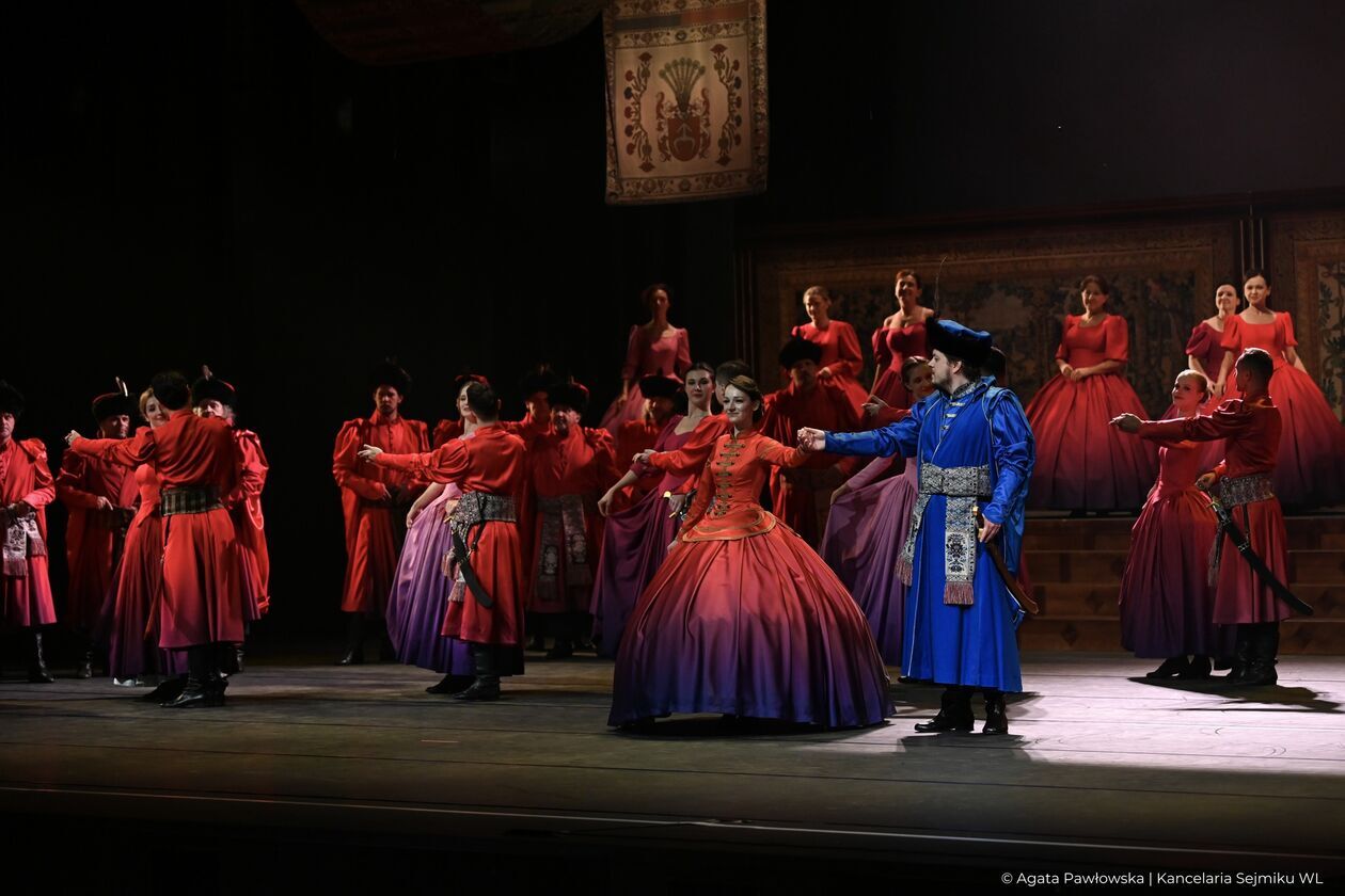 Zdjęcie przedstawia grupę śpiewaków operowych, ubranych w piękne kostiumy.