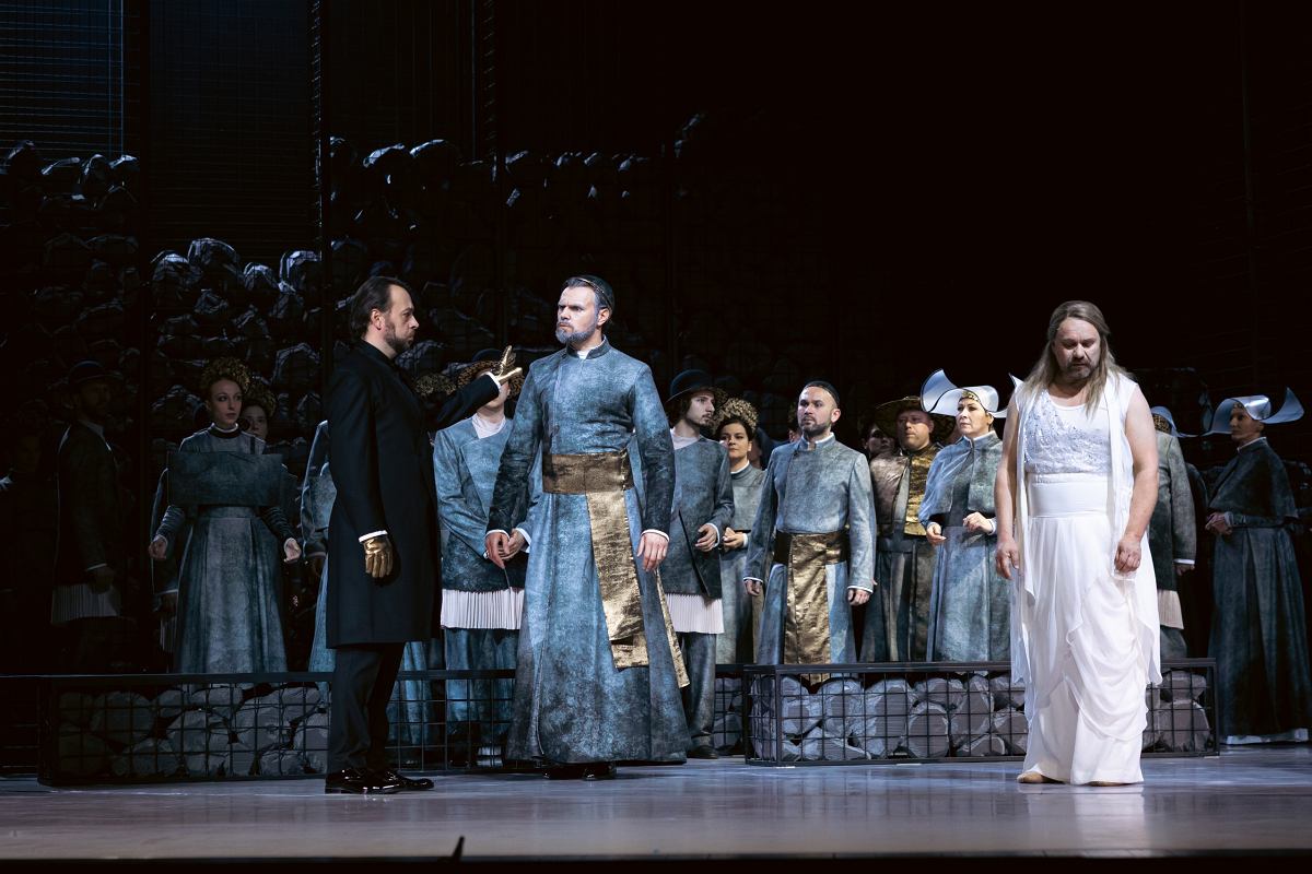 Na zdjęciu aktorzy ubrani w kostiumy utrzymane w kolorystyce szarości, dopełnione złotem.